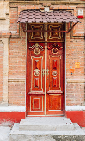 Old vintage wooden doors painted in red and goldの写真素材