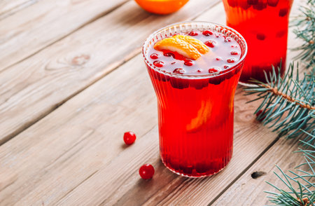 Christmas cranberry punch with oranges in glasses on rustic wooden table.の写真素材