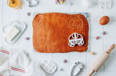 Cutting out Easter gingerbread in shape Easter bunnies from dark honey dough with spices.の写真素材