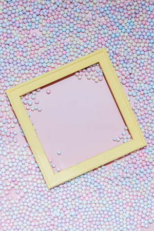 Pastel multicolored polyfoam balls background with yellow frameの写真素材