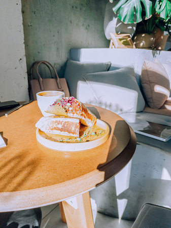 Vegan burrito with beans, cabbage and mushrooms on a yellow table in a cafe. Sunny dayの写真素材
