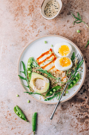 Healthy diet breakfast with grilled halloumi cheese, quinoa, egg and avocadoの写真素材