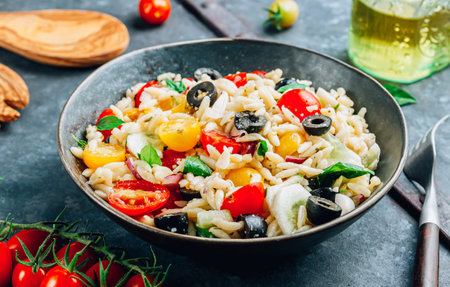 Mediterranean orzo salad with black olive, basil, red onion, tomato and cucumber.の写真素材