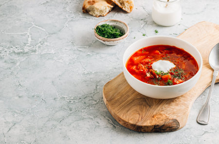 Traditional Russian and Ukrainian Borscht Meal with Bread, Sour Cream, and Fresh Herbs