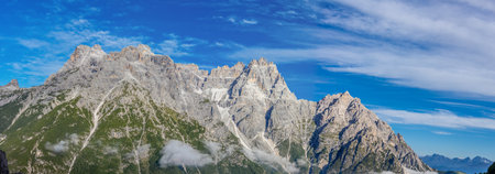 Panoramic view of the Dolomites in South Tyrol, Italy. Beautiful mountain landscape in the Alps on a sunny summer day with blue skyの写真素材
