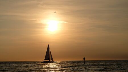 Clearwater Beach, Florida. A catamaran is sailing during one of the classic beautiful sunsets.の写真素材