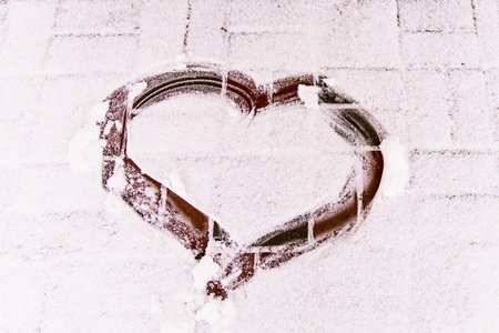 A heart drawn in the snow. Textured abstract backgrounの写真素材