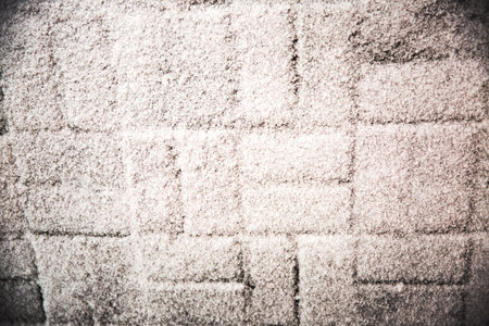 Fluffy snow lies on the dark tile. Textured abstract backgroun