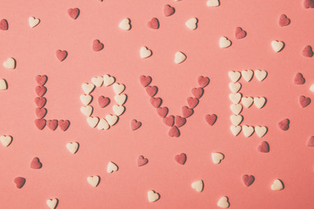 The word love written with hearts on a pink backgroundの写真素材