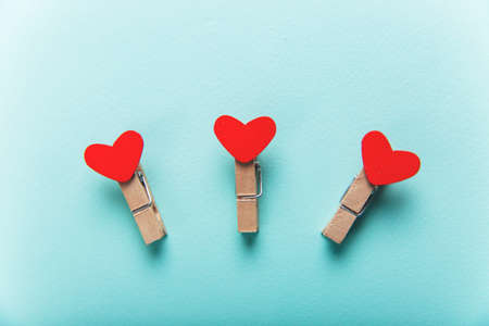 Wooden clothespins with hearts lie on a blue background. Great design for Valentine's Dayの写真素材