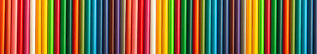 Colored pencils are arranged in a row on a light yellow background. Gradient color. Concept: banner on the topic of educational suppliesの写真素材