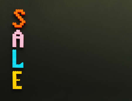 The inscription sale is laid out by the designer on a black background. Multicolored letters.の写真素材