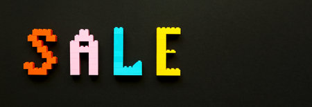 The inscription sale is laid out by the designer on a black background. Multicolored letters. Banner
