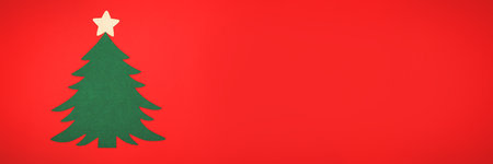 Green felt Christmas tree on a red background with a white wooden star on top. Banner. Concept: festive decoration.の写真素材