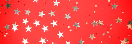 Sequins are scattered on a red background. Festive backdropの写真素材