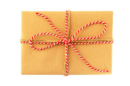 A Christmas gift beautifully packaged with craft paper and red thread. Isolate