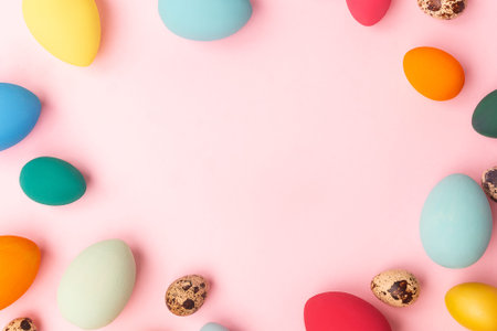 Colorful Easter eggs lie in a nest on a pink background. Easter holiday concept, flat lay.