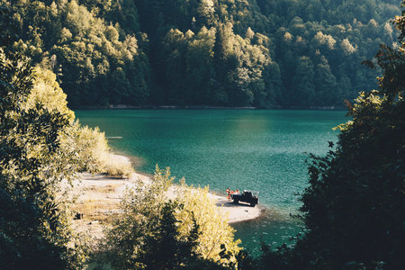 Recreation of a company of young people on the shore of a mountain lake.