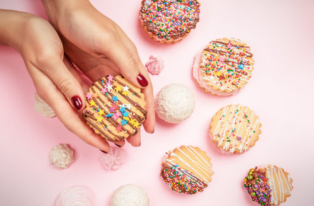 The hands of the pastry chef's girl hold homemade cookies sandwiches decorated with chocolate icing...