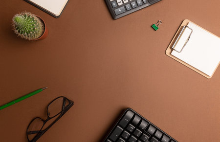 A workspace with stationery on a brown background. Concept: freelance, work from home.