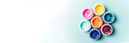Seven beautiful, bright, mother-of-pearl, multicolored open cans of paint on a bright colored background. The concept of creativity. Banner.の写真素材