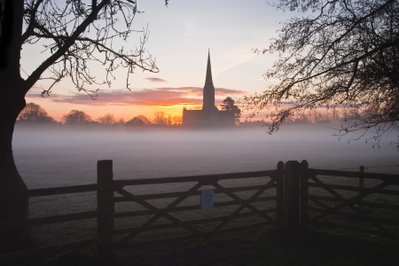A heavy mist being burnt off by the early morning sun across the water meadows.の写真素材