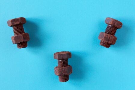 Rusty bolts and nuts made of chocolate isolated on sky blue background. Mechanic gearing background. Father's day card obectsの写真素材