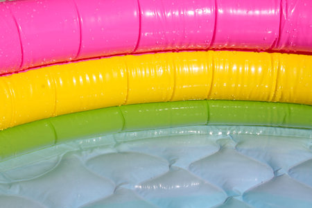 Bright blue inflatable paddling pool surface with water ripples. Summer picture of swimming pool...