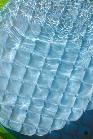 Bright blue inflatable paddling pool surface with water ripples. Summer picture of swimming pool....