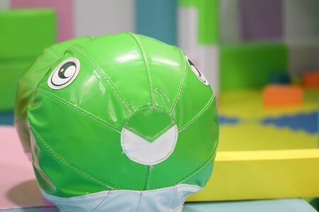 Funny green creature on merry-go-round attraction for toddlers. Kids playground object. Entertainment for happy children.の写真素材