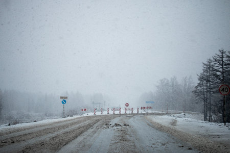 Detour road signs covered with snow during the snowfall in Magadan, Russiaの写真素材