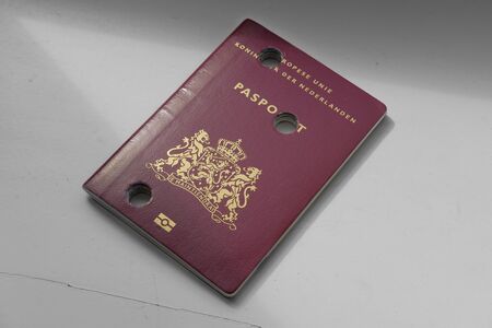 A Dutch passport made unusable with perforations on a plain backgroundの写真素材