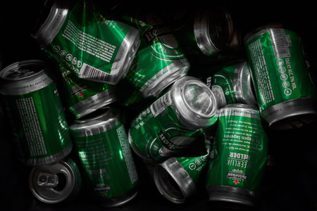 Many Heineken beer cans crumbled up in a trash can