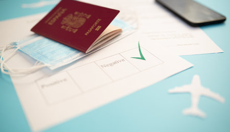 Passport with certificate of immunity, smartphone that shows health declaration, , ready to travel with surgical masks, new normal, travel safely, protocols, with blue backgroundの写真素材