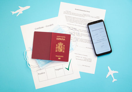 Passport with certificate of immunity, smartphone that shows health declaration, , ready to travel with surgical masks, new normal, travel safely, protocols, with blue backgroundの写真素材