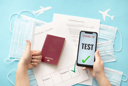 An international certificate of vaccination, a passport and surgical masks, on a blue background. Protocols and requirements for travel. Covid Passportの写真素材