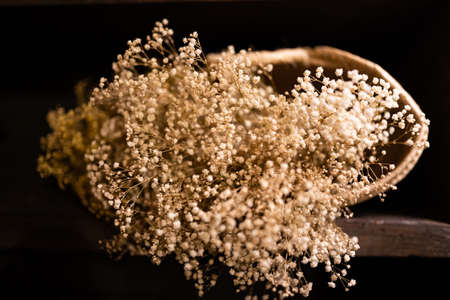 Dried flowers, in a basket, with a black backgroundの写真素材