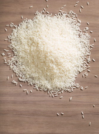 A pile of white jasmine rice  over a wooden backgroundの写真素材