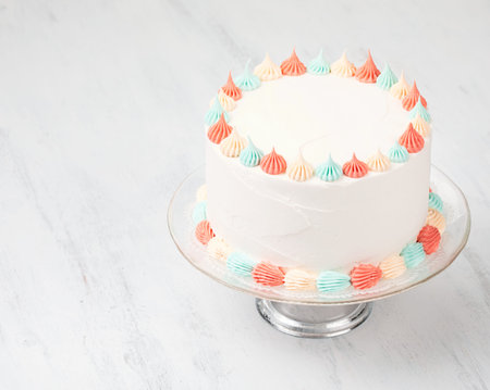 Bright Buttercream Birthday cake with pastel colored icing over a white
