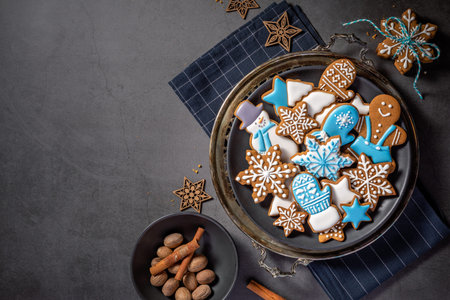 Decorated Blue and White iced gingerbread Christmas cookies on rustic platter with spices. Dark Grey...
