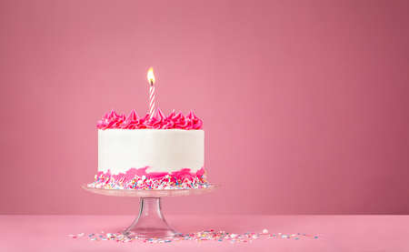 Pink Birthday Cake with Candle on pink backgroundの写真素材