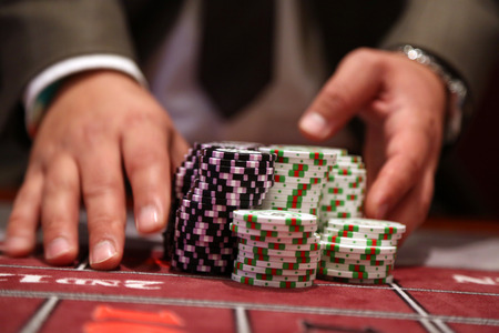 Player at gambling table pusing large stack of chipsの写真素材