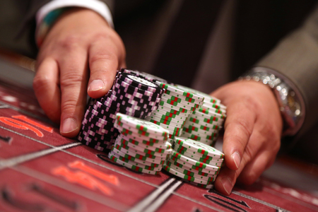 Player at gambling table pusing large stack of chipsの写真素材