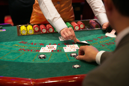 Dealer puts down a card on blackjack tableの写真素材