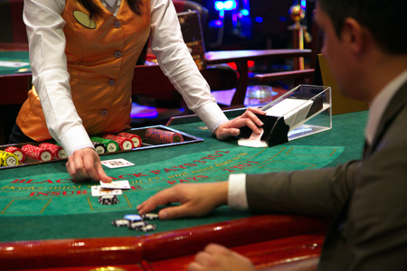 Dealer puts down a card on blackjack tableの写真素材