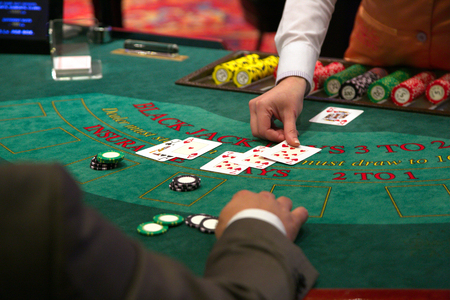 Dealer puts down a card on blackjack tableの写真素材