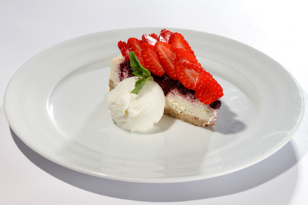 strawberry cake with ice cream on white plateの写真素材