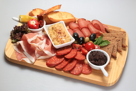 A mix of salami, cheese, ham on a plateauの写真素材