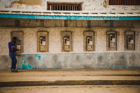 CUBA in December 2015: A male person uses a public payphone to make a call. Public phones are the...