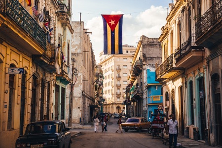 Havana, Cuba in December 2015: A cuban flag with holes waves over a street in Central Havana. La Habana, as the locals call it, is the capital city of Cubaのeditorial素材
